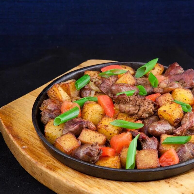 Картошка с овощами и курицей на сковороде. Горячая сковородка с бараниной и овощами. шипящая сковородка с бараниной. жаркое на сковороде. картошка с мясом на сковородке.
