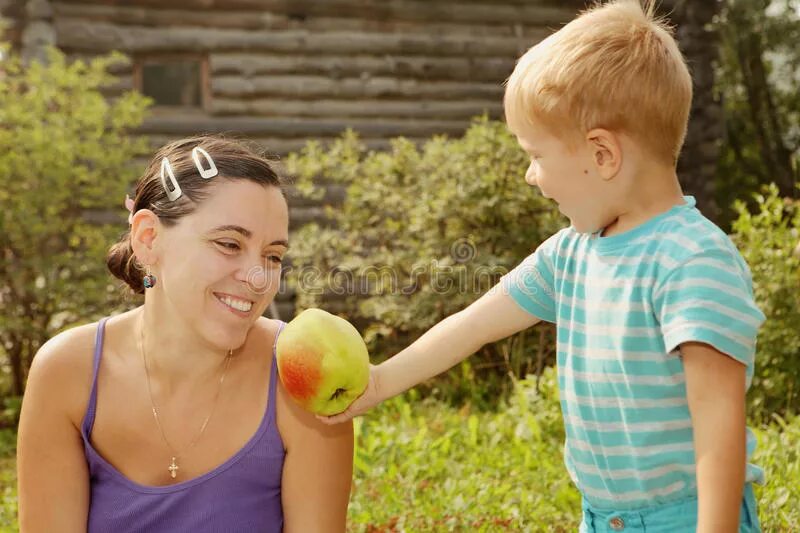 Мальчик протягивает яблоко. Девочка протягивает яблоко. Мальчик дает маме яблоко. Мальчик угощает девочку яблоком.
