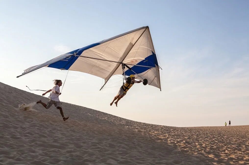 Полет с помощью. Kitty hawk kites. летающий змей дельтаплан. воздушный змей дельтаплан. первый полет на дельтаплане.