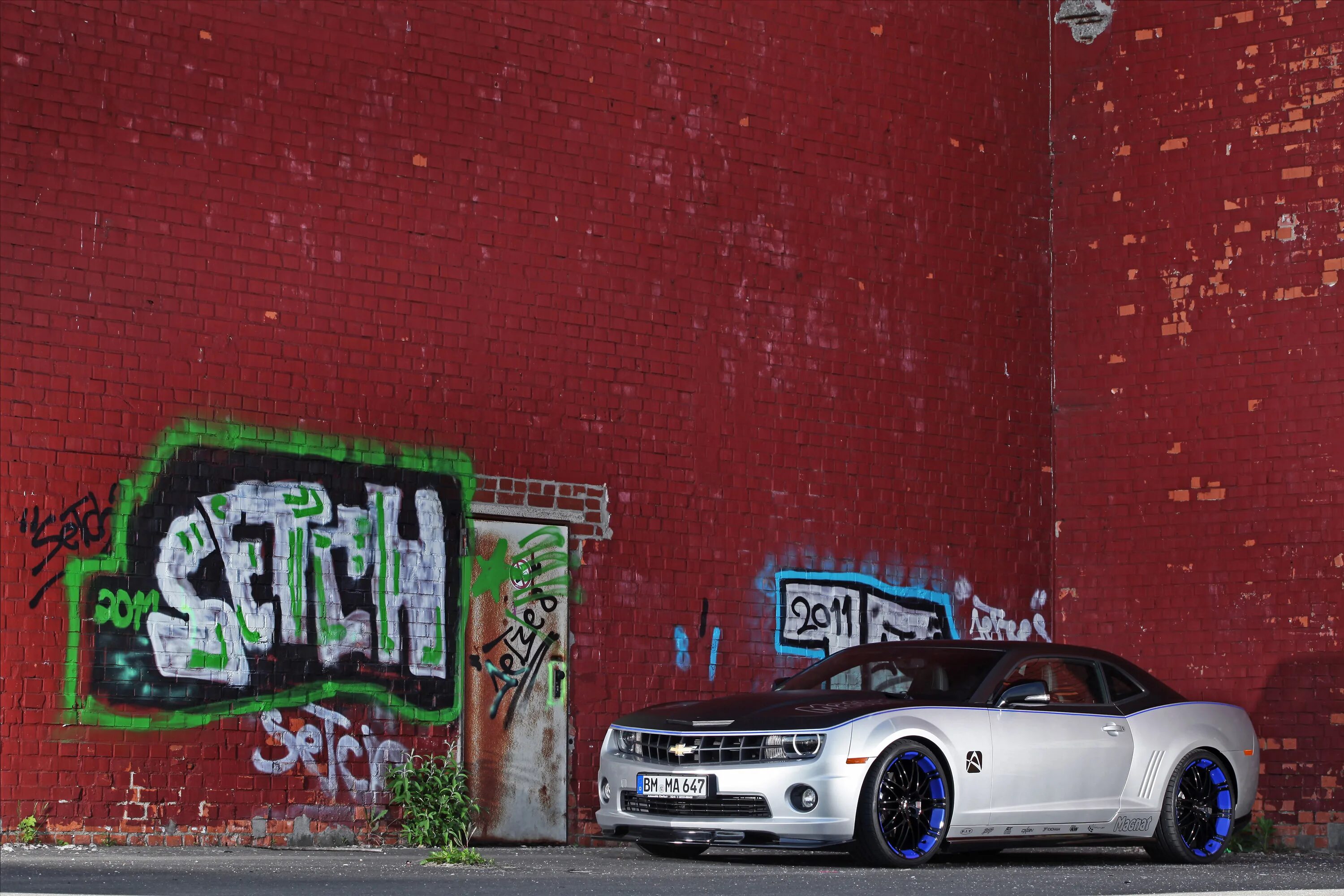 Машина на фоне стены. Граффити на авто. Граффити на кирпичной стене. Авто на фоне кирпича.