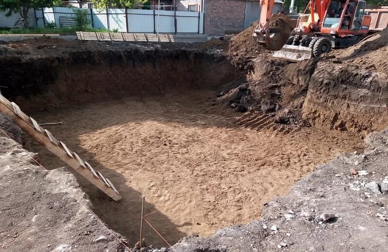 Котлован под фундамент нового здания. Котлован под ленточный фундамент. котлован под дом. копка котлована. траншея под фундамент.