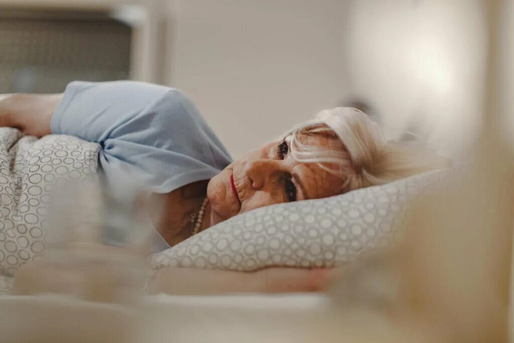Пожилая женщина мучается бессонницей. Нарушение сна на диализе. Потоотделение ожирение. Лишение сна Альцгеймер.