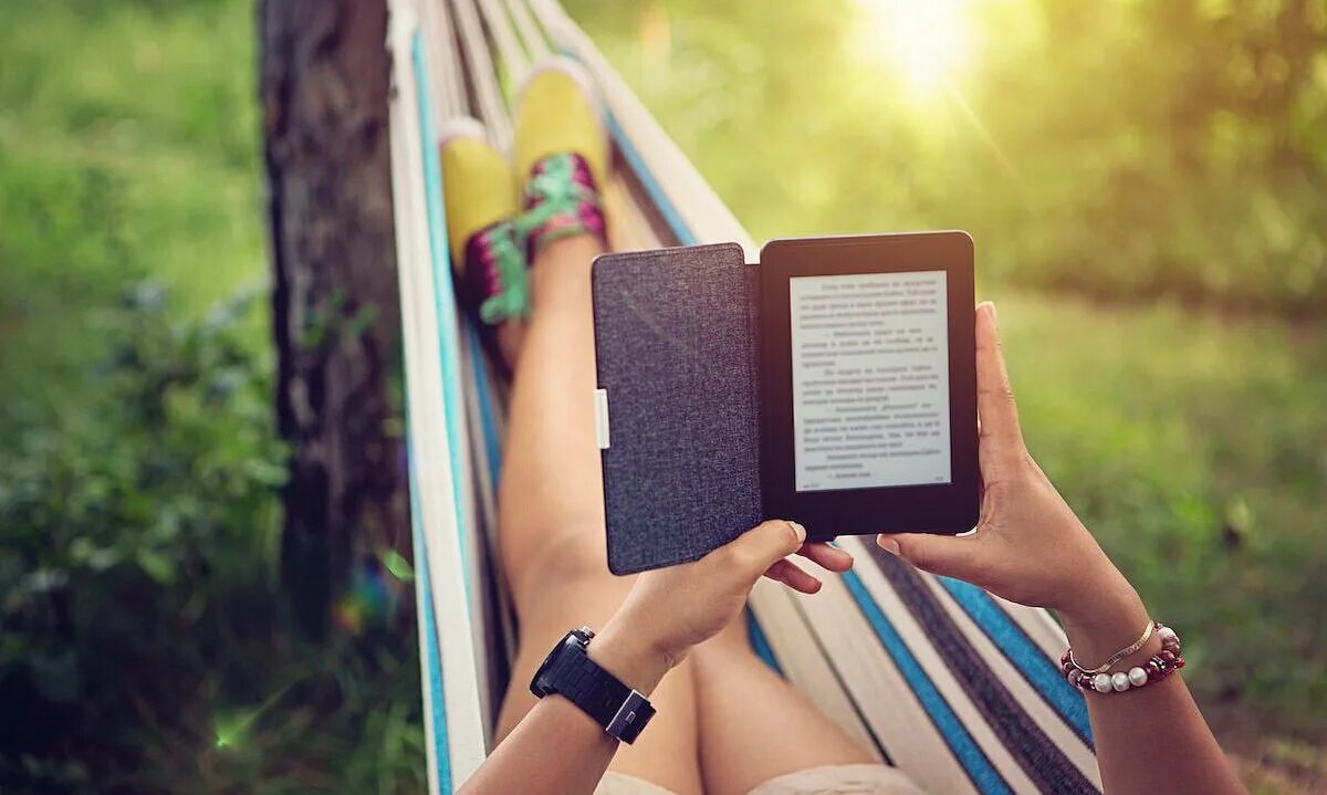 Подборка книг для лета. Девушка читает электронную книгу. девушка с книгой. электронная книга в руках. девушка с электронной книгой.
