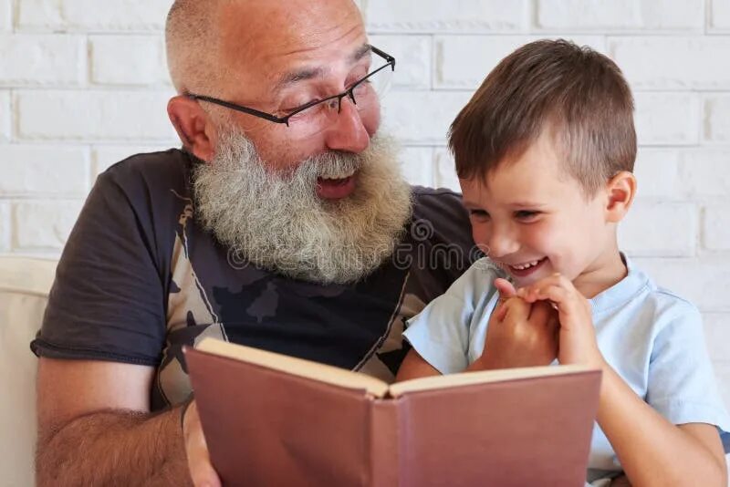 Дедушка с книгой. Бабушка дедушка и внуки. Дед читает внуку. Бабушка и дедушка с внуками. Пожилые с книгой.
