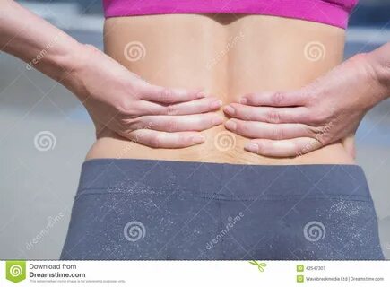 Подходящая женщина касаясь ее больной задней части Стоковое Изображение - изобра