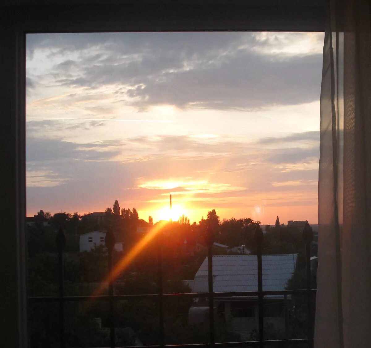 В окнах отражается солнце. Вид из окна. Солнечный вид из окна. Солнце из окна. Закат в окне.