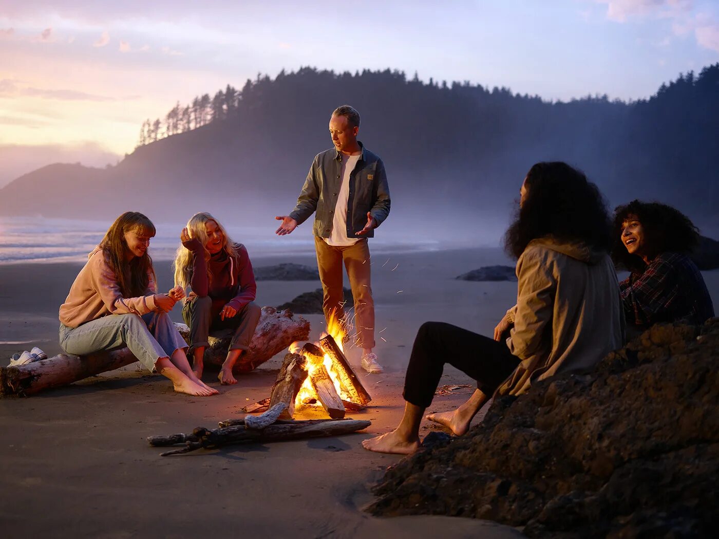 Group of people around Bonfire. By the Campfire stock images. People around Bonfire Seaside. Adventure vk