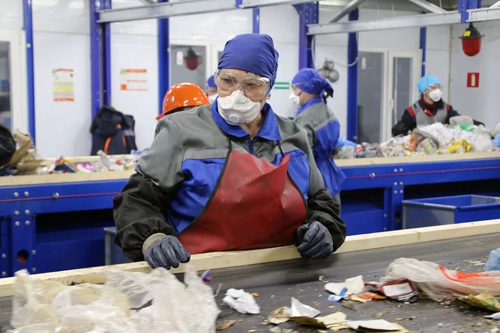 сортировочный цех. процесс переработки макулатуры. линия ручной сортировки мусора. швеция мусоропереработка завод. сортировщик на заводе.