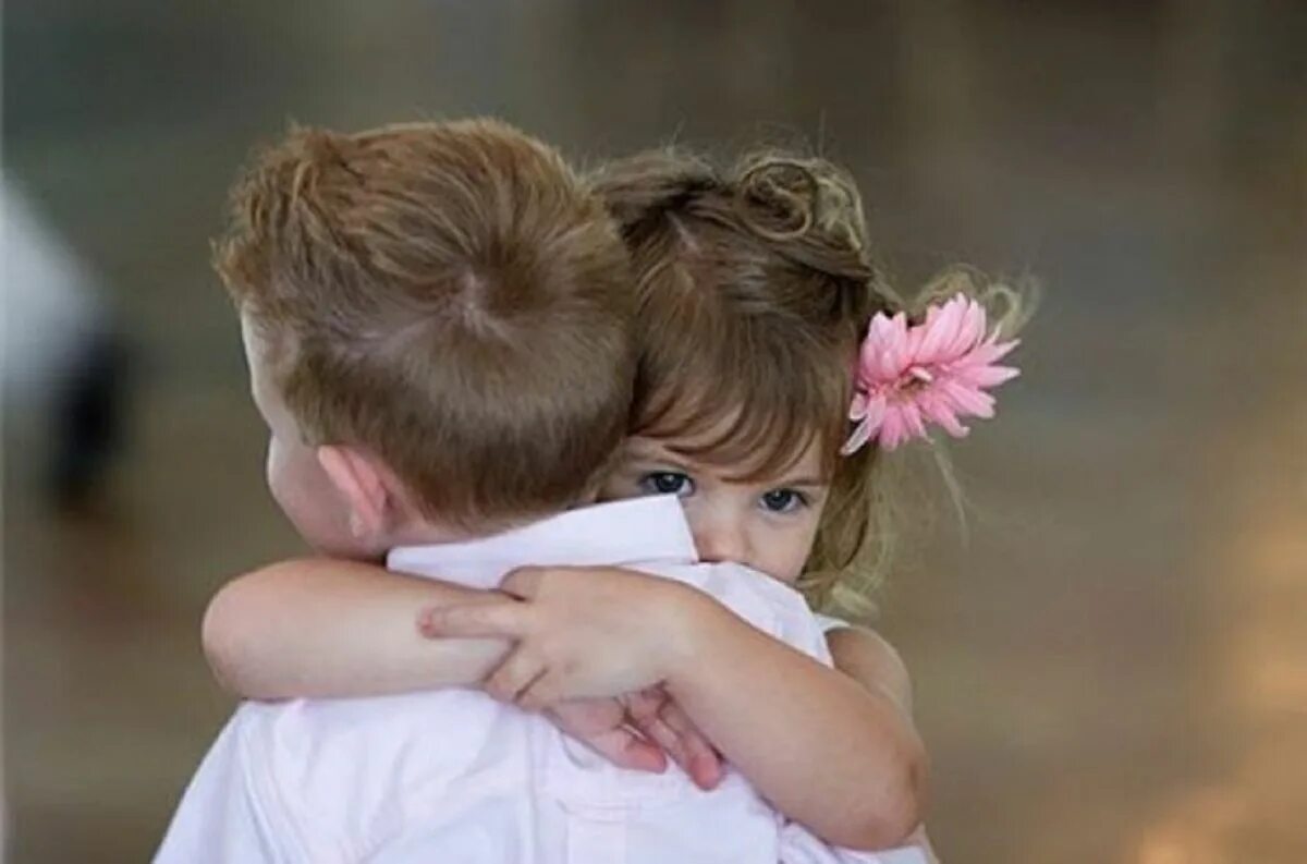 Человек прощает другого человека. Мальчик и девочка обнимаются. Мальчик обнимает девочку. Объятия детей. Любовь к ребенку.