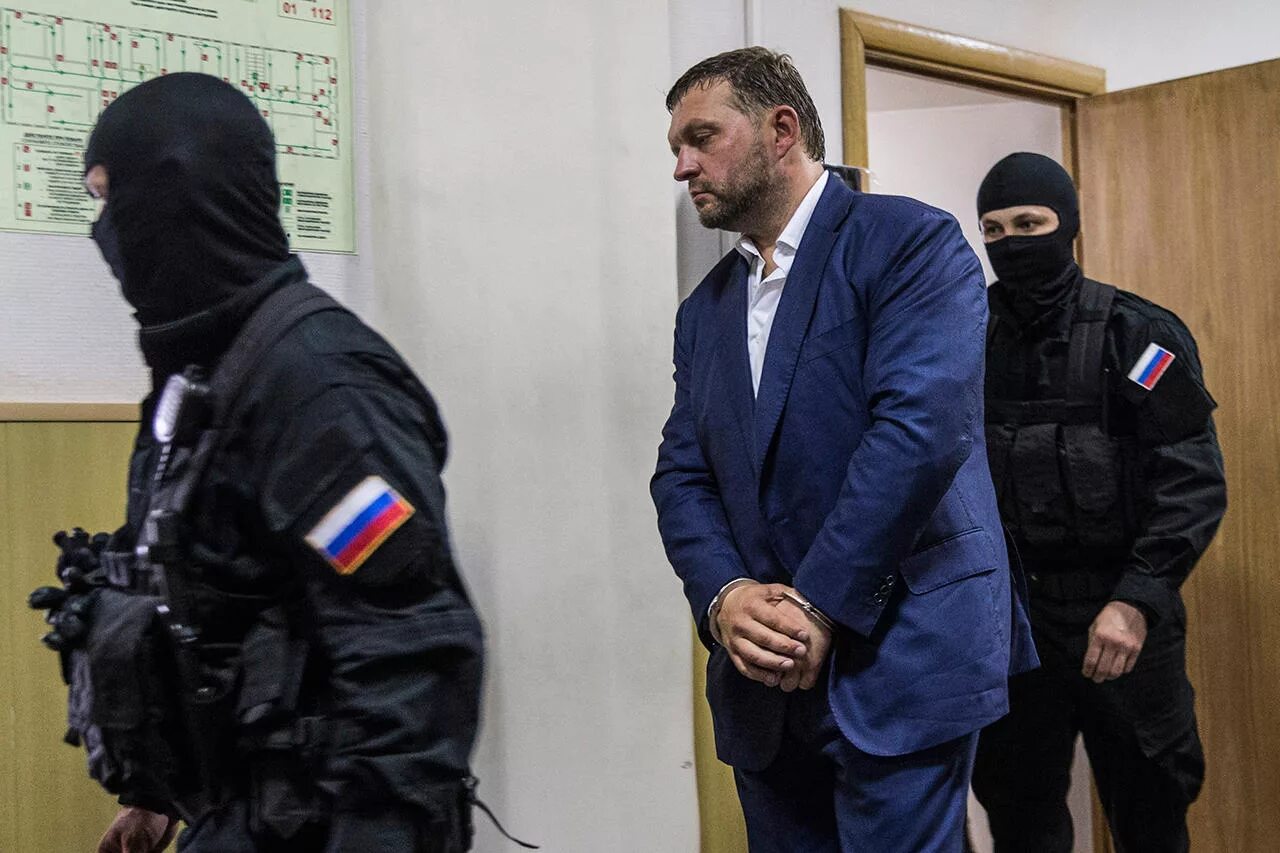 преступник за решеткой в суде. задержание наручники. преступник в наручниках. арестованный в наручниках. преступление.