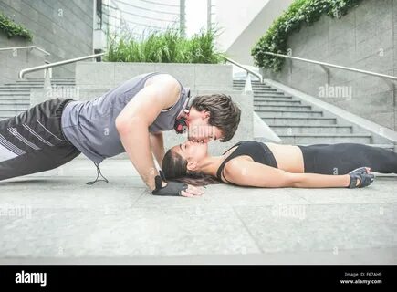 Couple of young handsome caucasian sportive man and woman stretching - he i...