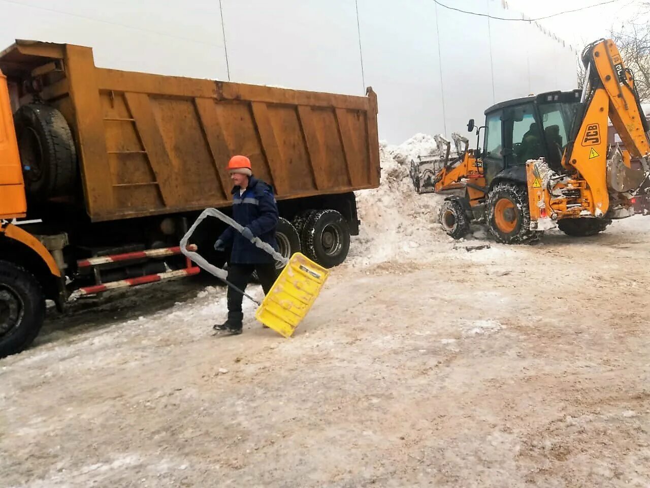 Трактора грузят. Вывоз снега. Уборка снега самосвал. Уборка и вывоз снега. Погрузка снега в самосвал.
