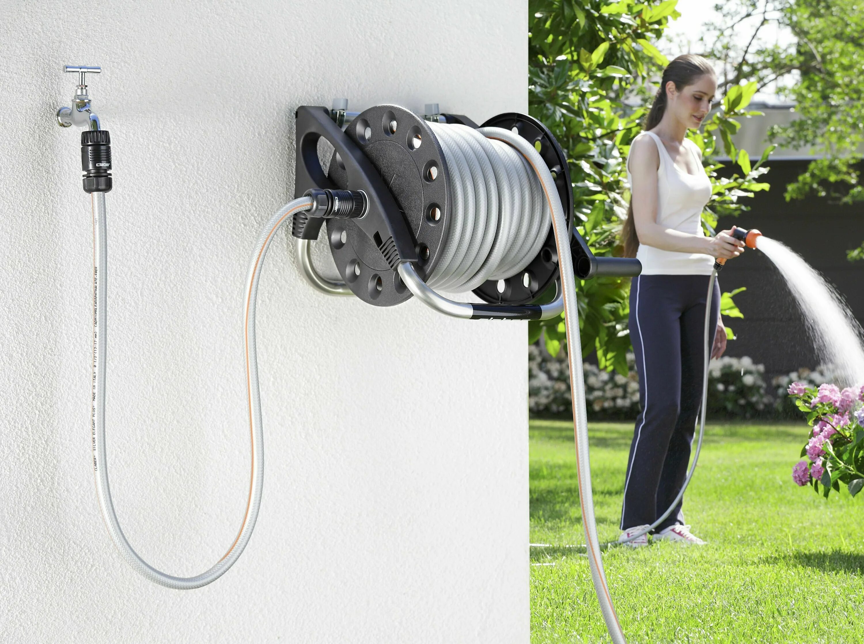 Толстый шланг в руке. Садовник поливает газон. Поливать масло с помощью отвёртки. Шланг для воды. Поливает водой девушку из шланга.