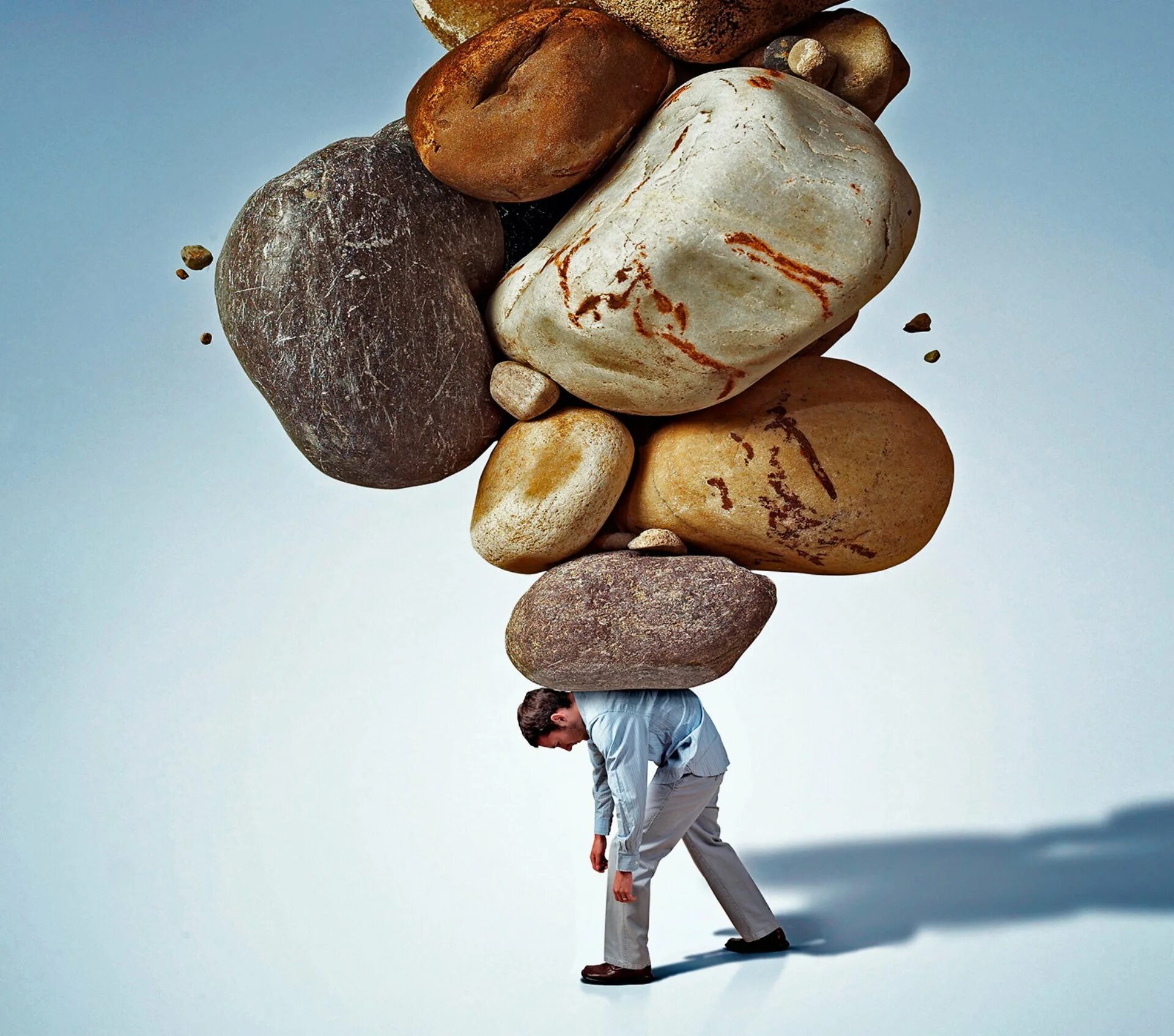 Сила и упорство. Человек под тяжестью. Ответственность человека. Мысли в голове. Человек под камнем.