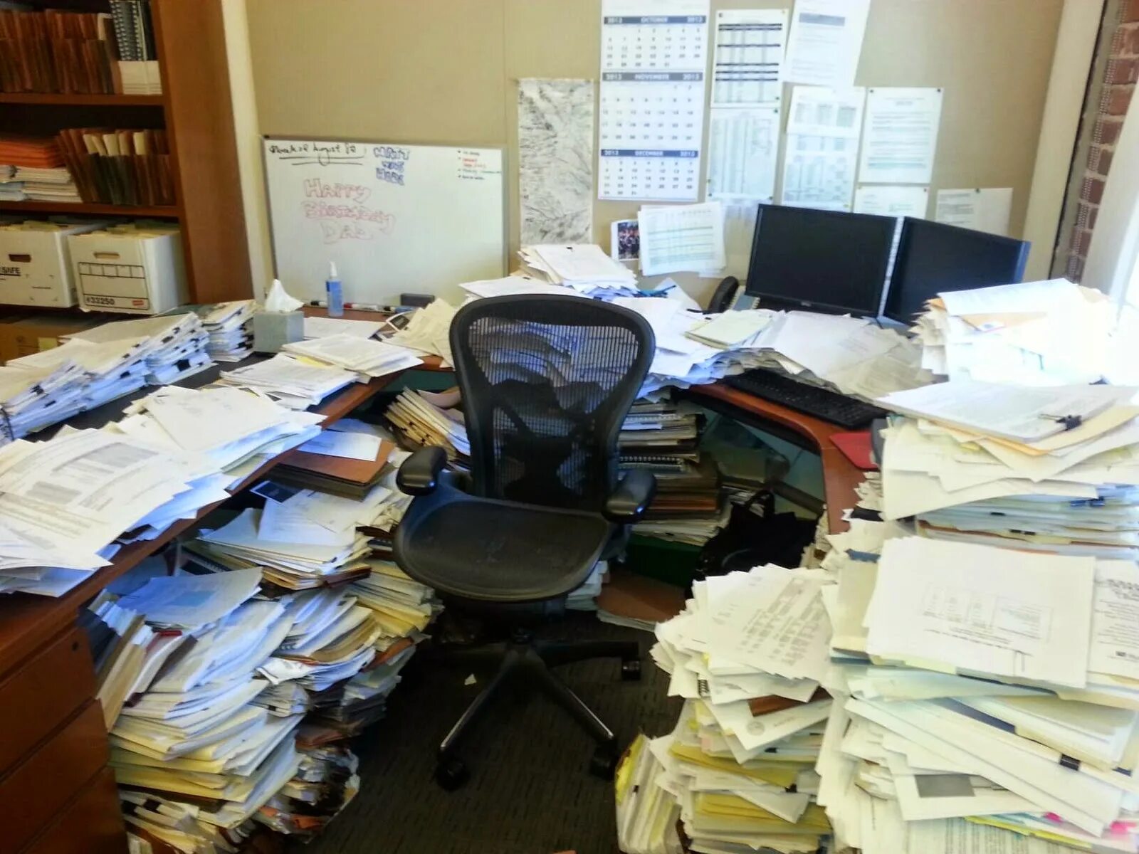 Office papers. Стол заваленный бумагами в офисе. Бардак в бумагах. Много бумаг на столе. Завал на офисном столе.