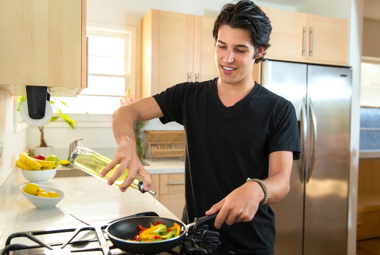 He cooks well. Мужчина на кухне. Мужик на кухне. Мужчина на кухне Shutterstock. Мужчина со сковородкой.