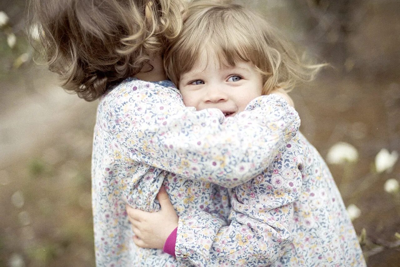 Девочка обнимает. Сестренки обнимаются. Девочка обнимает девочку. В объятиях сестры.
