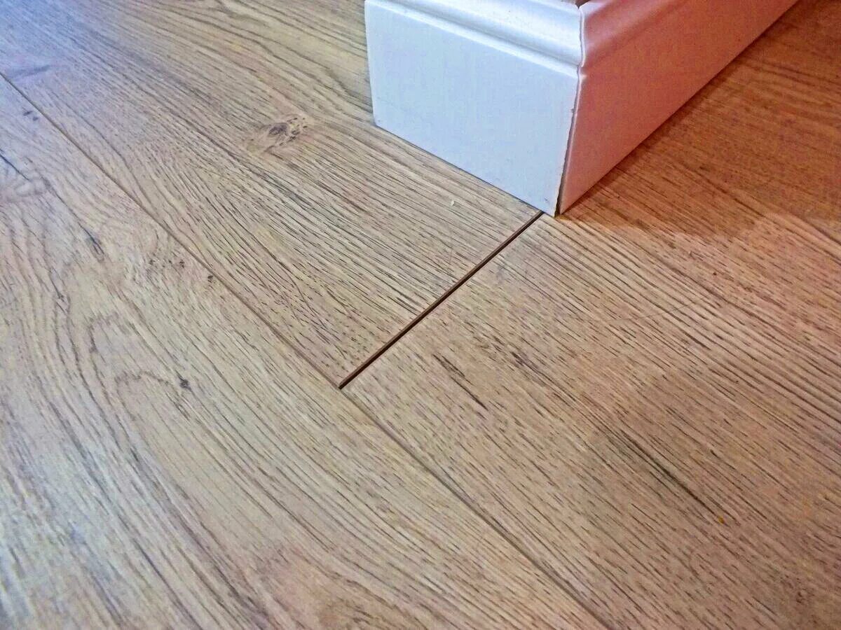 Вздутие ламината. Ламинат расходится укладке. Вздулся ламинат. Щели в ламинате. Ламинат расходится укладке.