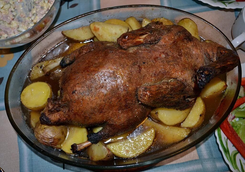 Утка запеченная в духовке с яблоками. Запеченный Гусь. Гусь запеченный в духовке с картошкой. Утка с картошкой.