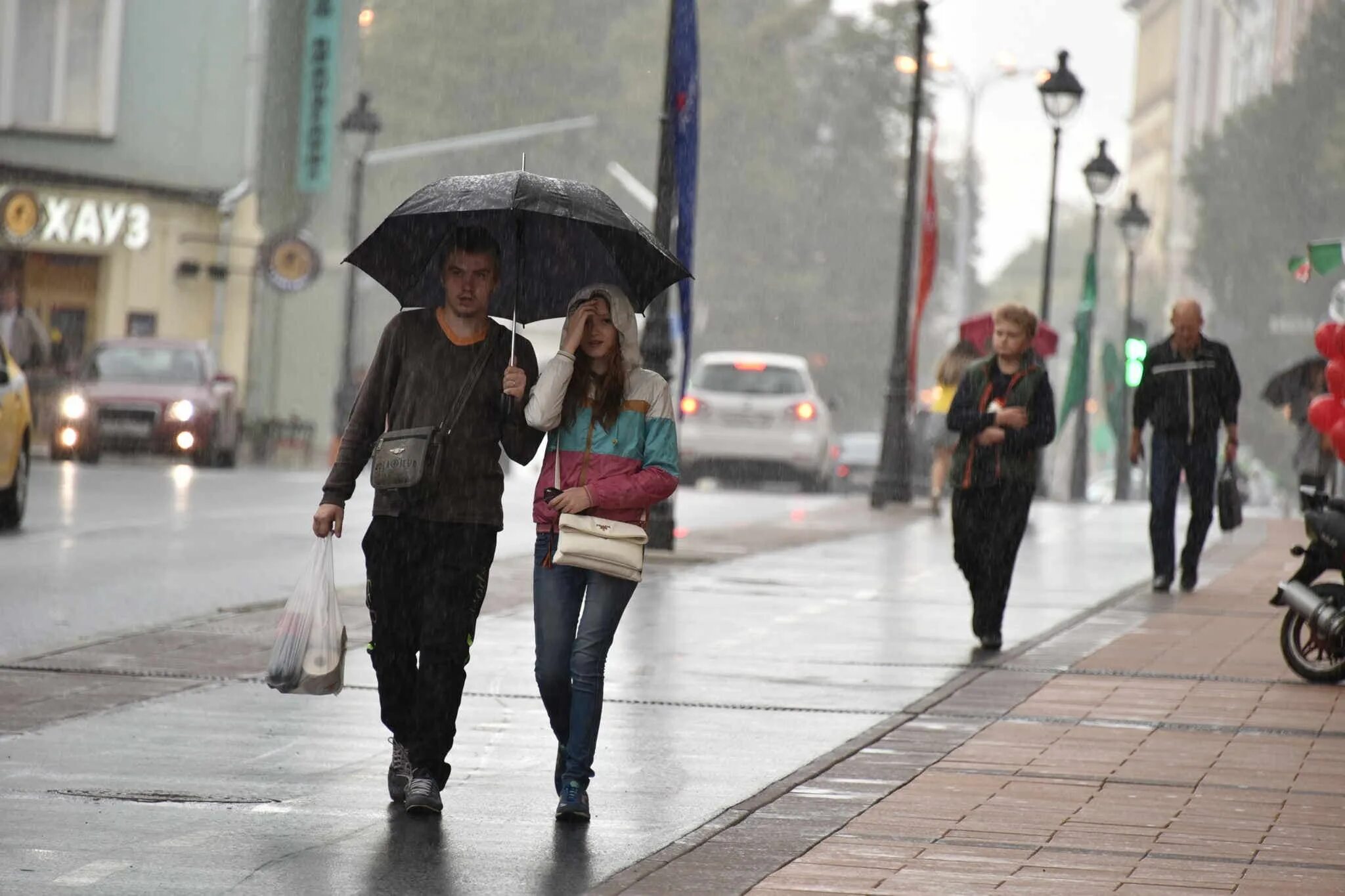 В городе 70000 жителей. Люди в городе. Люди на улице. Дождливый день. Прохожие на улицах города.