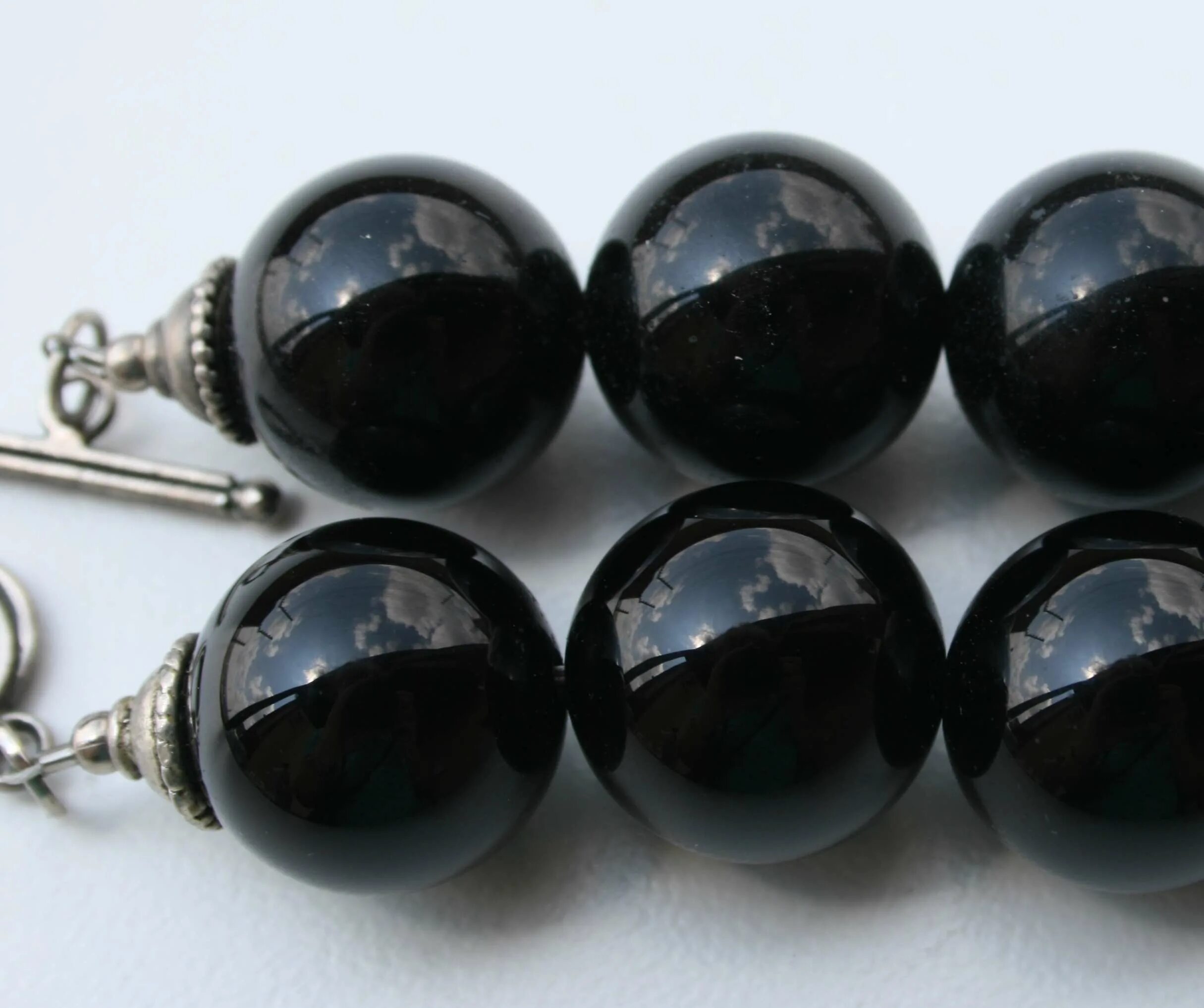 Темный оникс камень. Гагат гематит агат. Оникс камни по знакам зодиака. Черный оникс с полосками. Камень черный с белыми полосами.