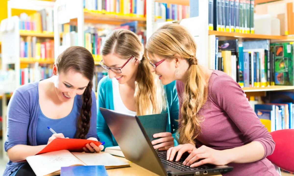 Старшеклассники в библиотеке. Две девушки в библиотеке. Students are in library. Студенты университета, библиотека. Студенты в библиотеке.