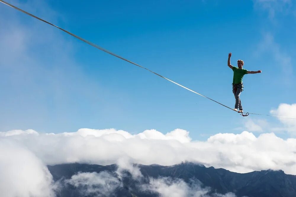 Хождение по канату. Балансирует на канате. Человек на канате. Бесстрашный человек. Человек на канате.