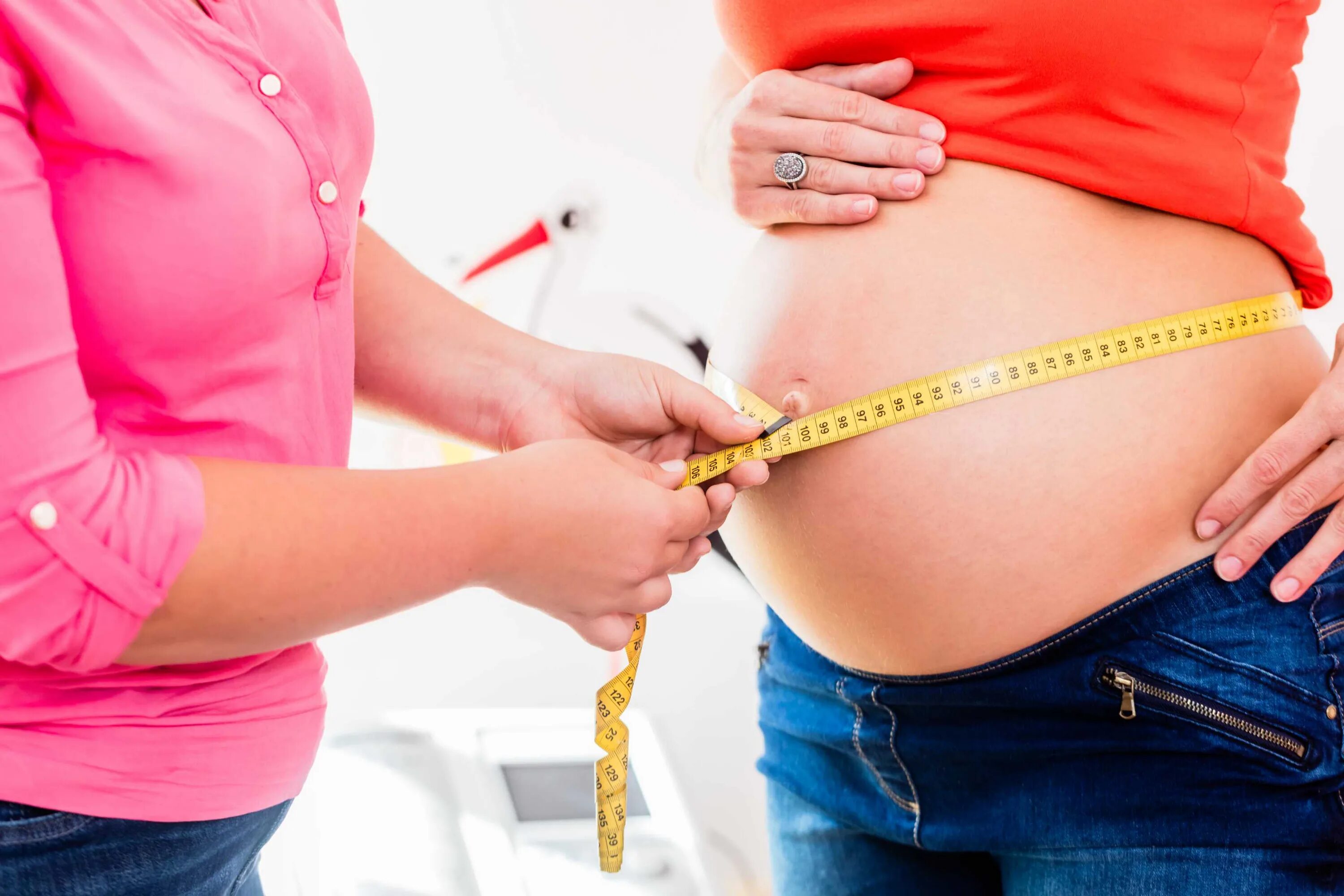 Забеременеть стоя можно. Измерение окружности живота беременной. Акушерка измеряет. Как стоят беременные.
