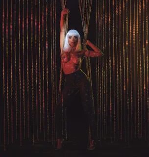 Her platinum wig shines brilliantly in the red lighting as... 
