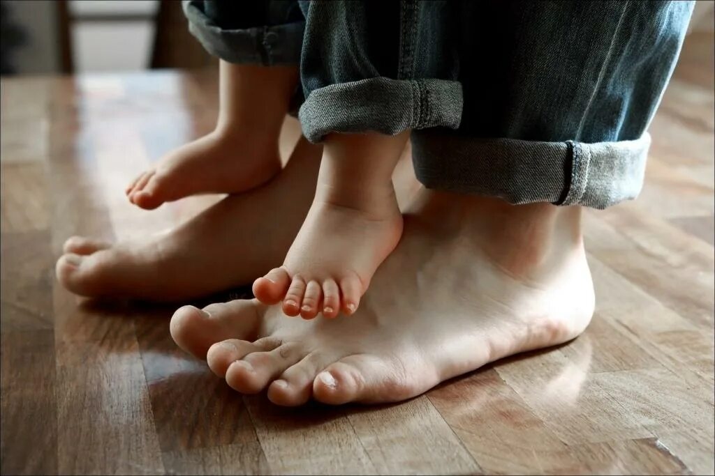 У мамы есть ноги. Стопы детские и взрослые. Ножки ребенка на полу. Детская и взрослая нога.