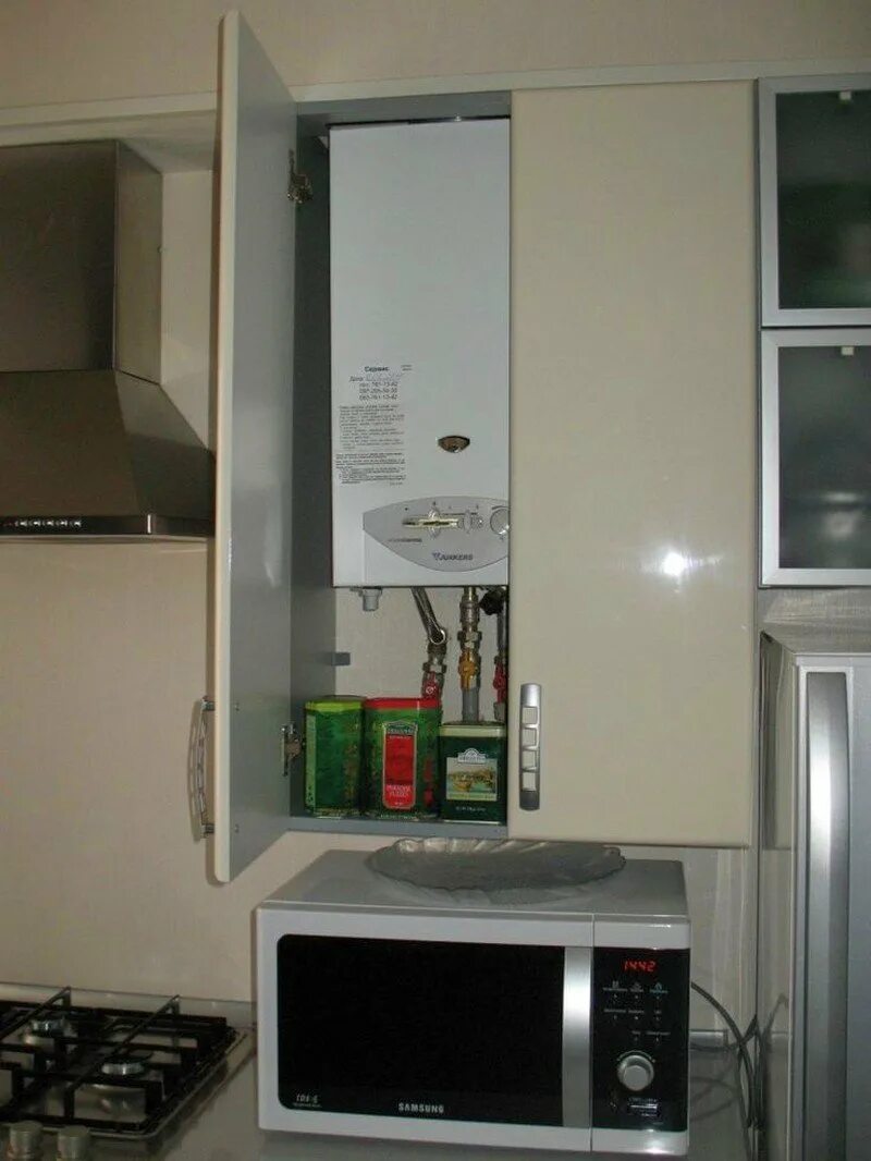 Можно ли газовую колонку прятать в шкаф. Газовая колонка на кухне. микроволновка под газовым котлом. газовый котёл на кухне в интерьере. газовая колонка в шкафу.