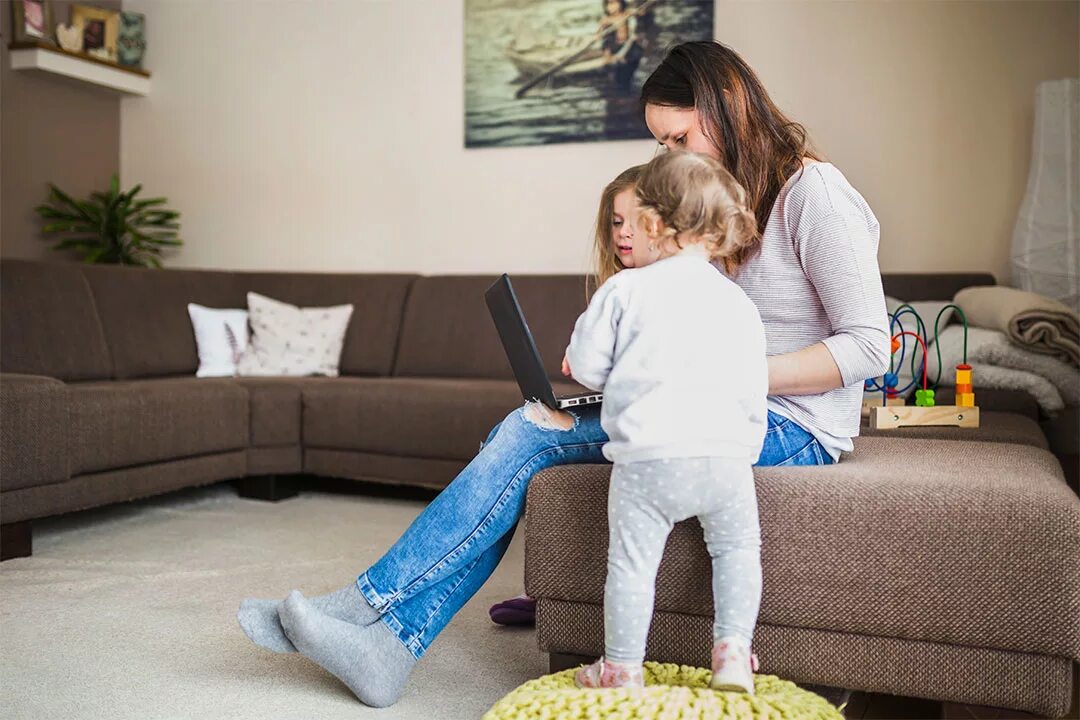 Sad Family Sofa. Sister sits on lap. Family sitting on Sofa.