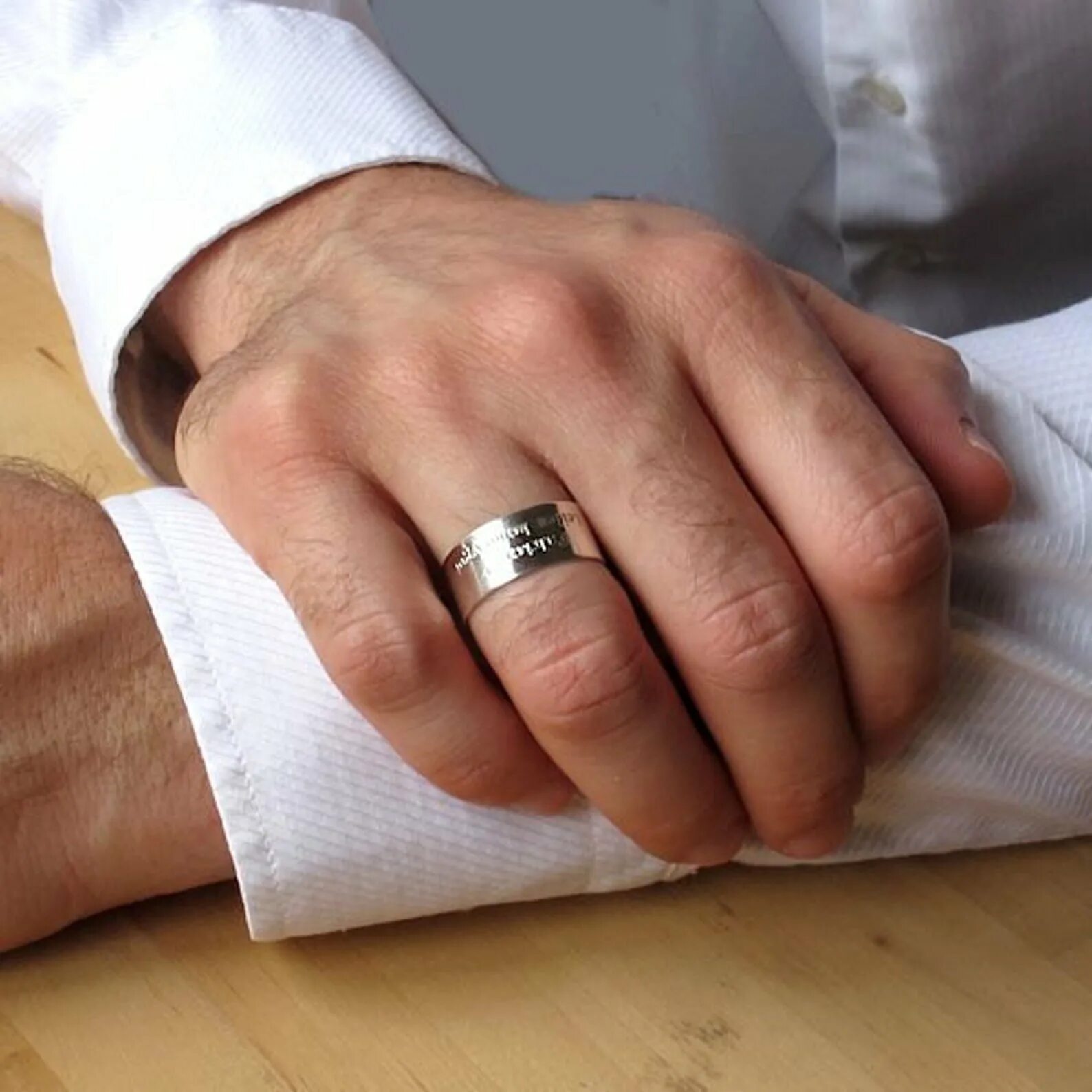 Муж обручальное кольцо. Мужское обручальное кольцо. Мужские обручальные кольца на руке. Широкое обручальное кольцо на руке. Гравировка на кольцах.