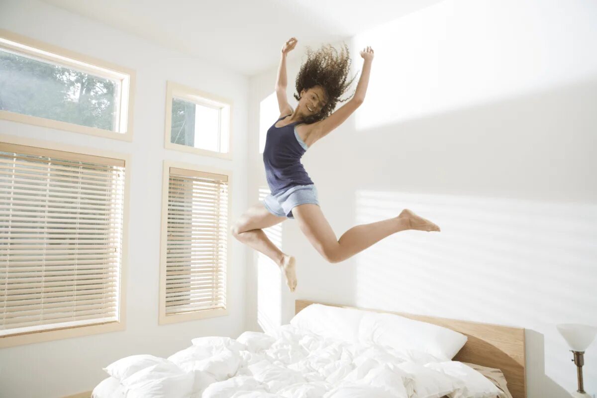 Встать посередине. Девушка в прыжке. Девушка прыгает. Девушка прыгает на кровати. Бодрость утром.