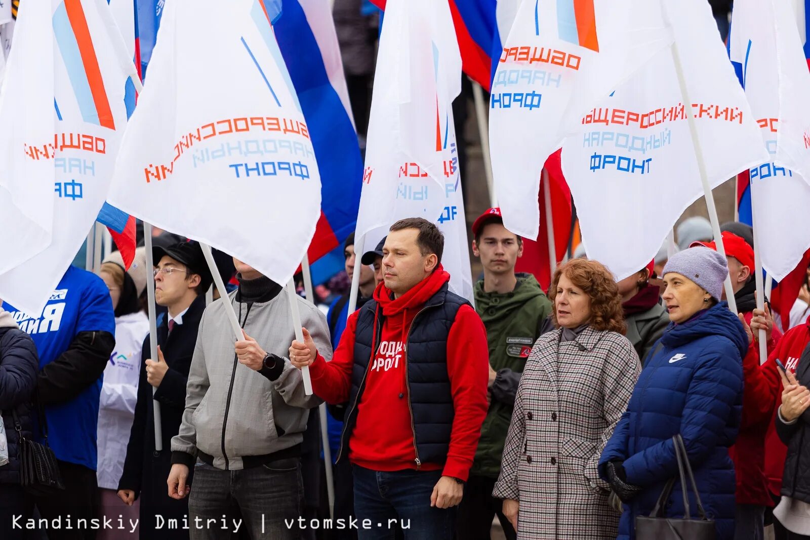 Митинг концерт единой россии. В поддержку присоединения с Россией. Люди стоящие с флагом свободной России на митингах. Флаг народного фронта. Журналист на митинге.