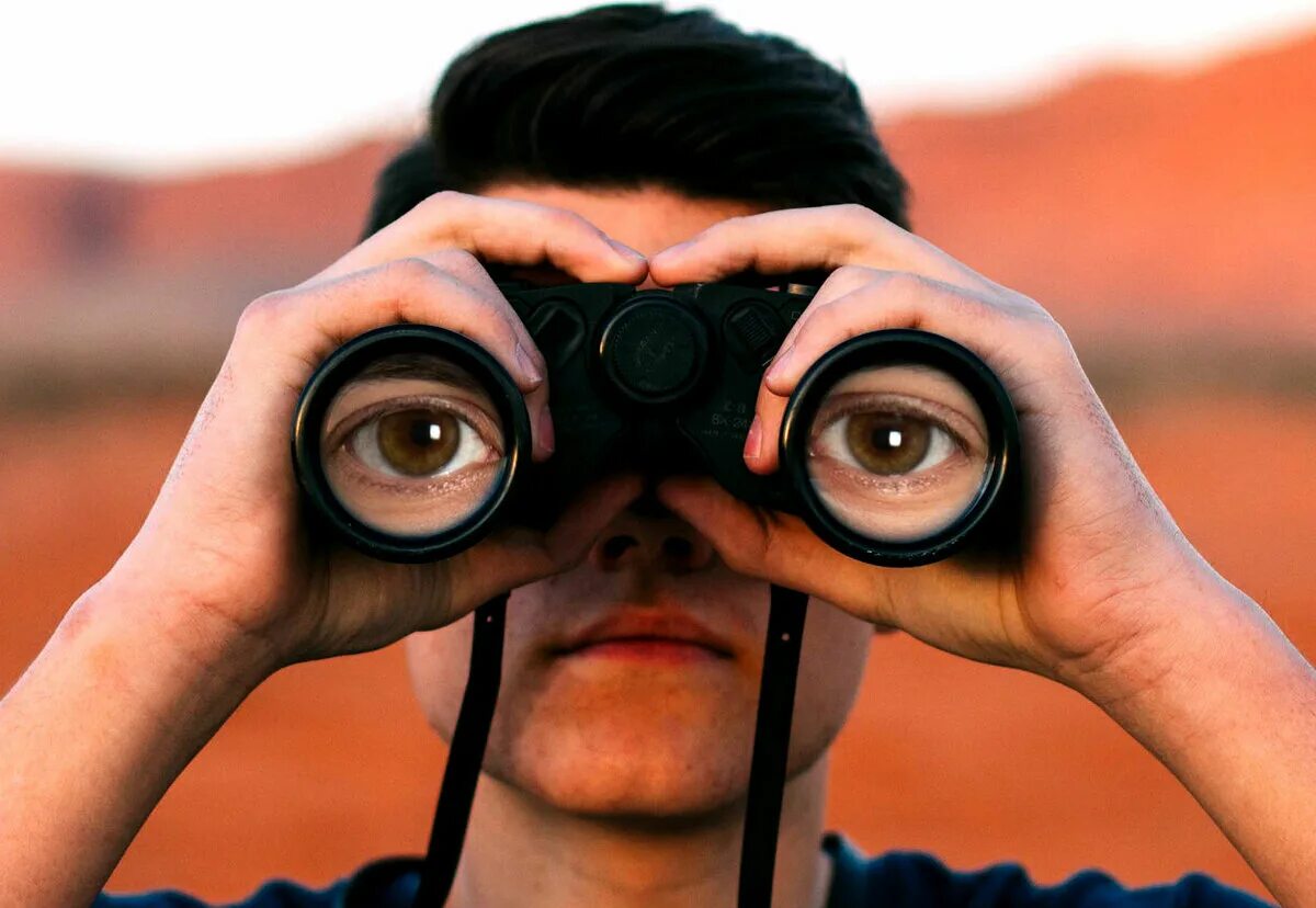 Парень с подзорной трубой. Мужчина с биноклем. Парень с биноклем. Наблюдать удивить. Мужчина с биноклем.