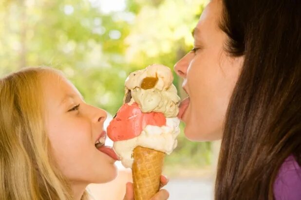 Ребенок облизывает мороженое. Шерегеш лыжницы. Летними лижи. Горнолыжный курорт одежда. Девочка лижет.