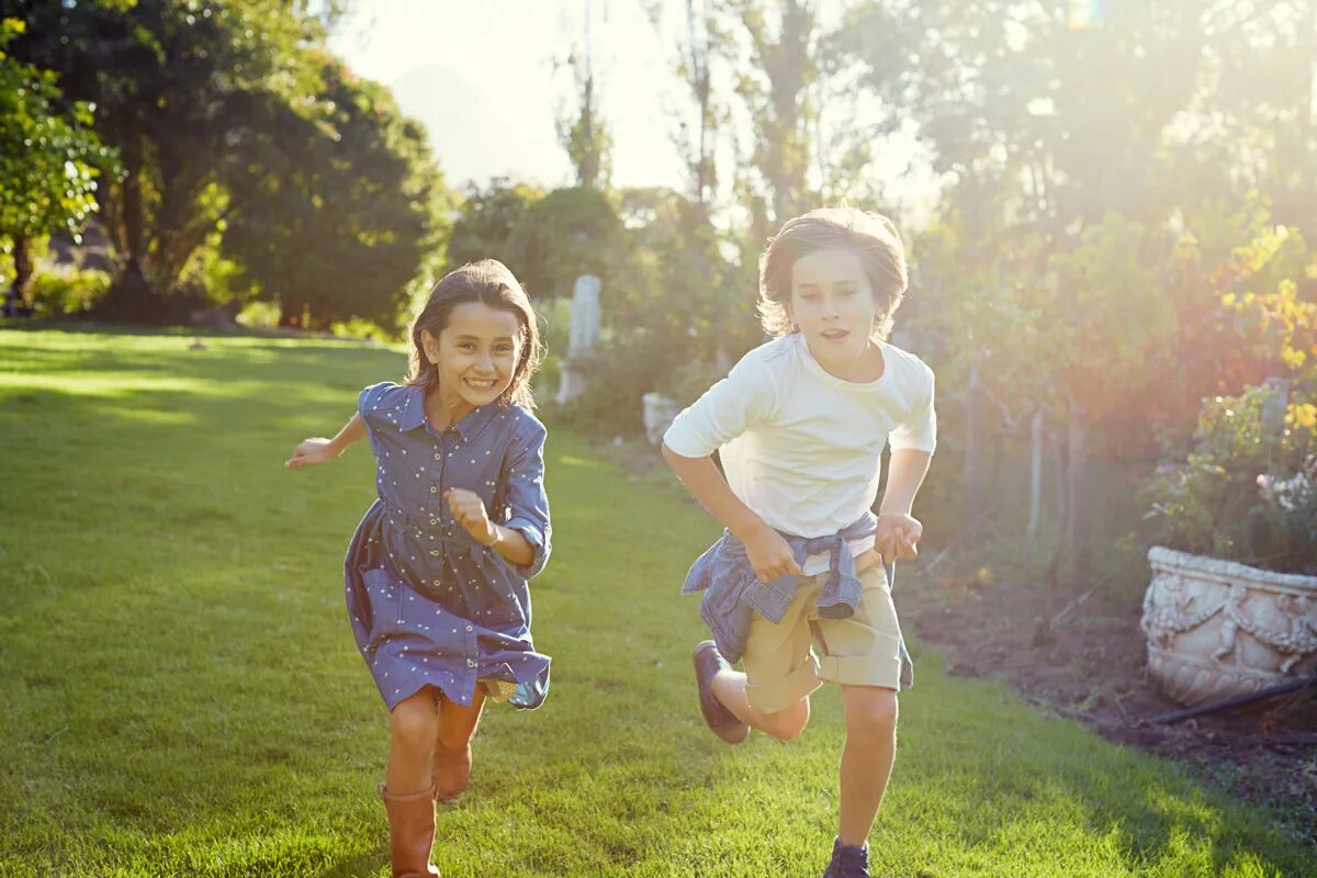 Дети бегают. Девочка бежит. Дети бегут по траве. Мальчик бежит за девочкой.