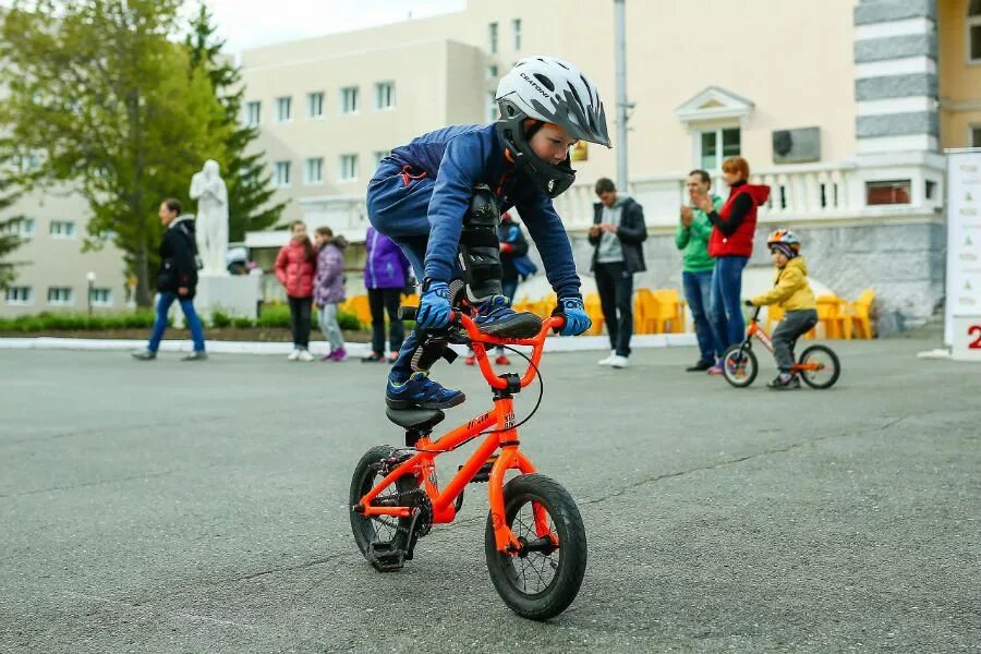 Дети катаются на беговеле