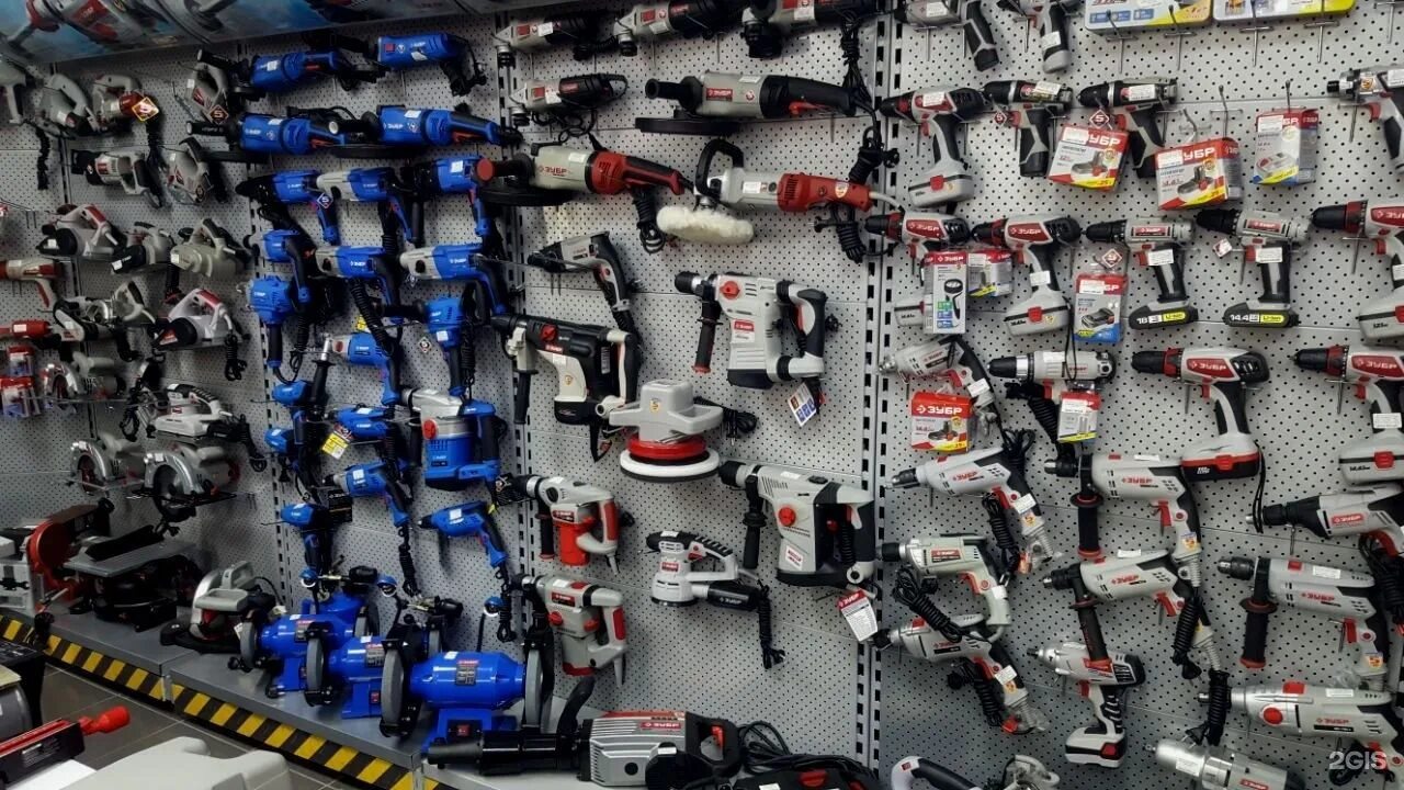 оптовые торговля инструментом. оптовые торговля инструментом. комплектация заказов на складе. люди в магазине. выкладка электроинструмента.