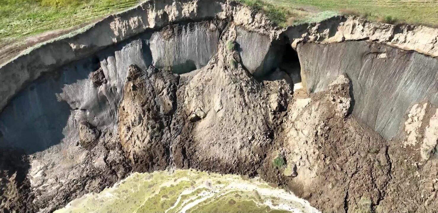Впадина в вечной мерзлоте 4. Карстовая воронка на ямале. Твердомерзлые грунты. Кратер батагайка якутия. Сибирский кратер батагайка.