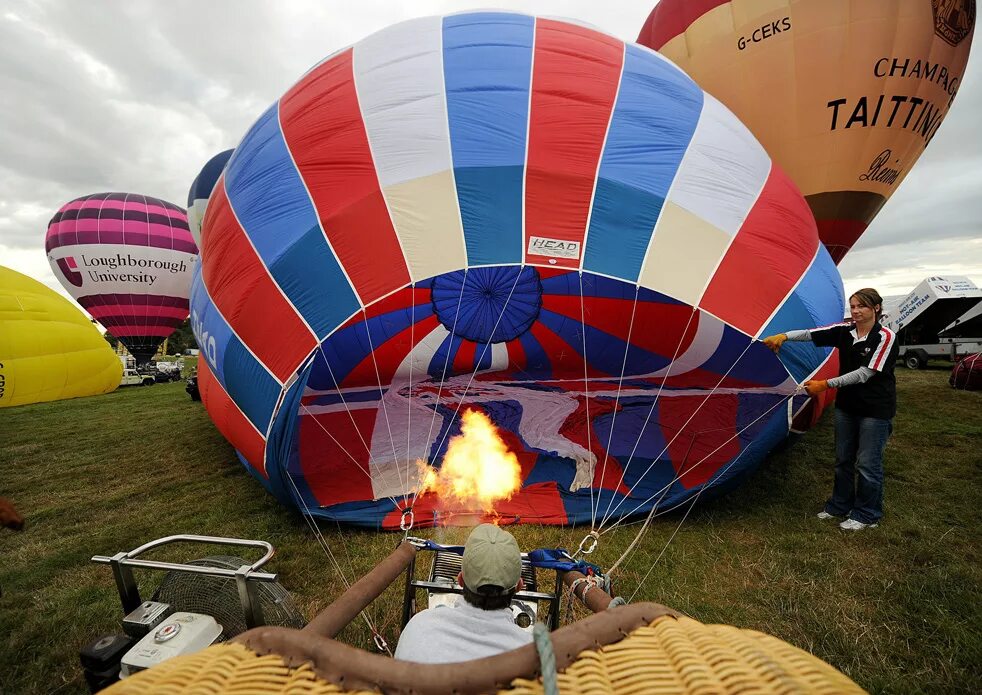 Шары запускать воздух. Фестиваль воздушных шаров в Бристоле. Надувает воздушный шар. Надувают воздушный шар для полетов. Воздушный шар аэростат.
