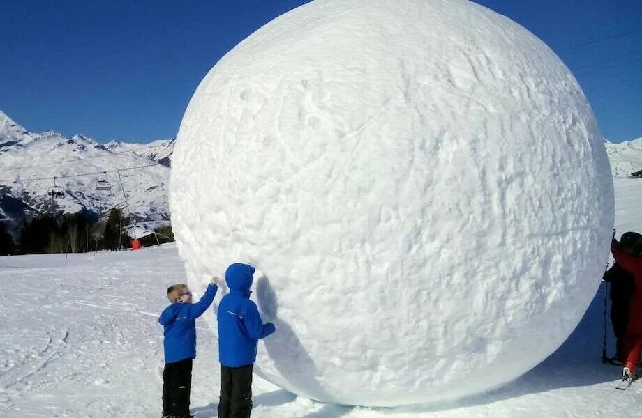 В шаре с горы. Огромный снежок. Шар из снега. Снежный комок. Большой шар из снега.