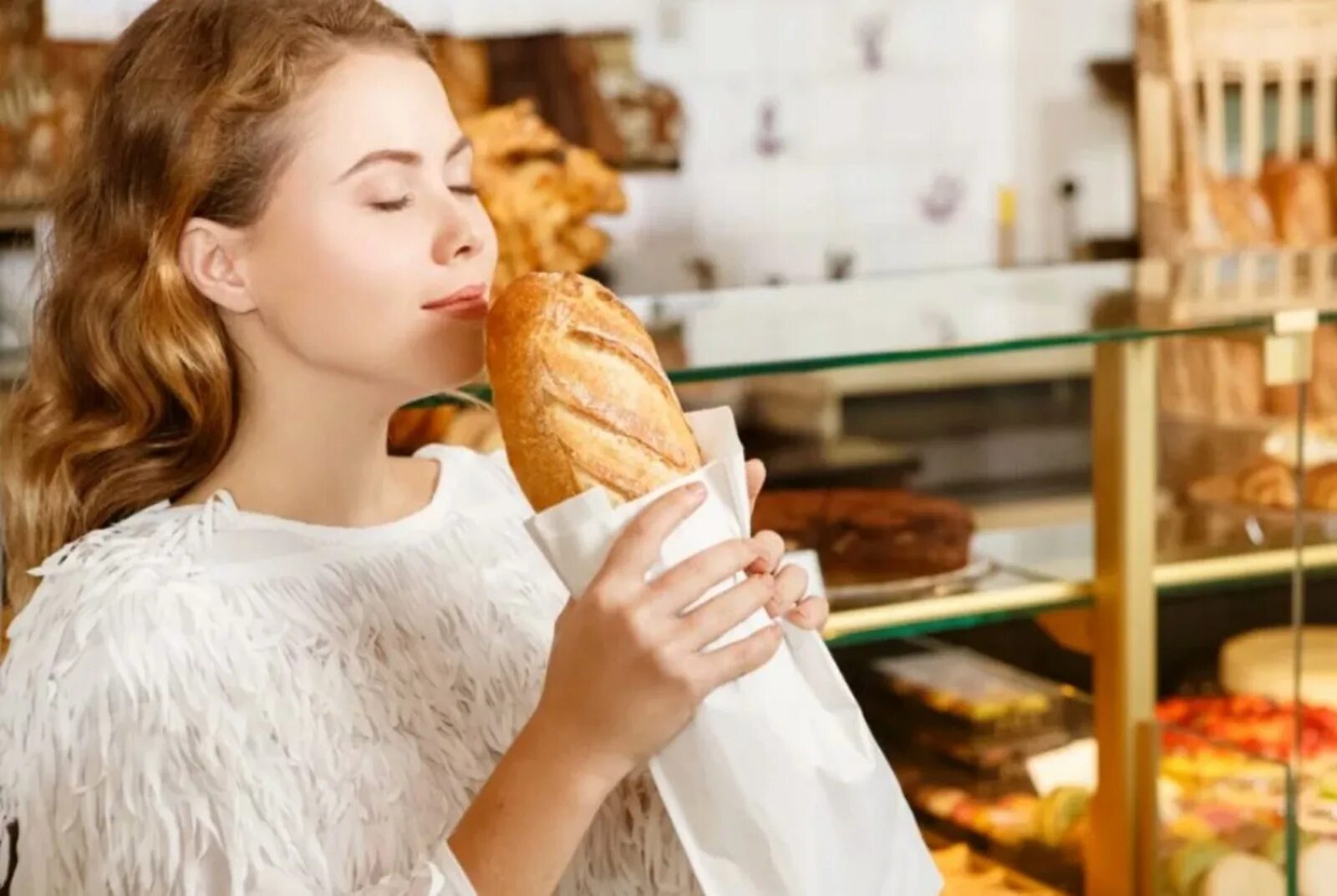 Человек есть много хлеба. Девушка в булочной. Девушка с выпечкой. Запах свежей выпечки. Девушка ест выпечку.