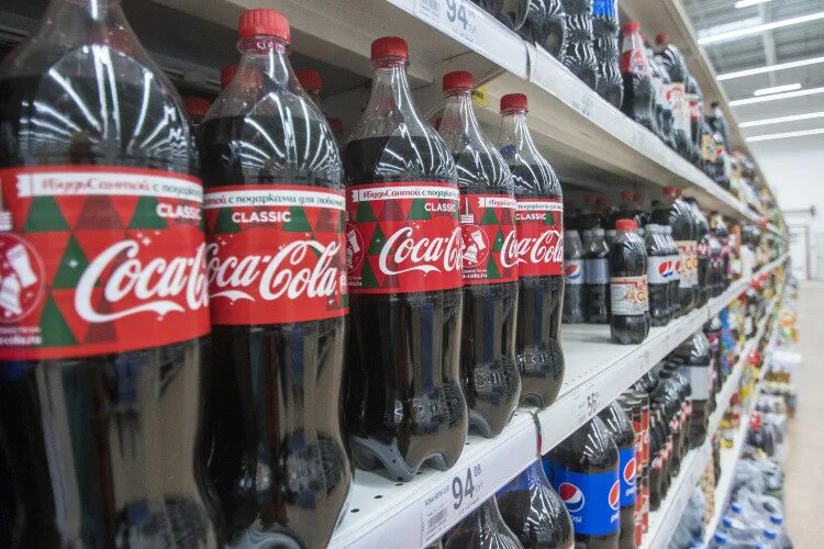 Кока кола на прилавке. Газированные напитки в магазине. Витрина кока-кола. Coca cola магазин. Кола магазин.