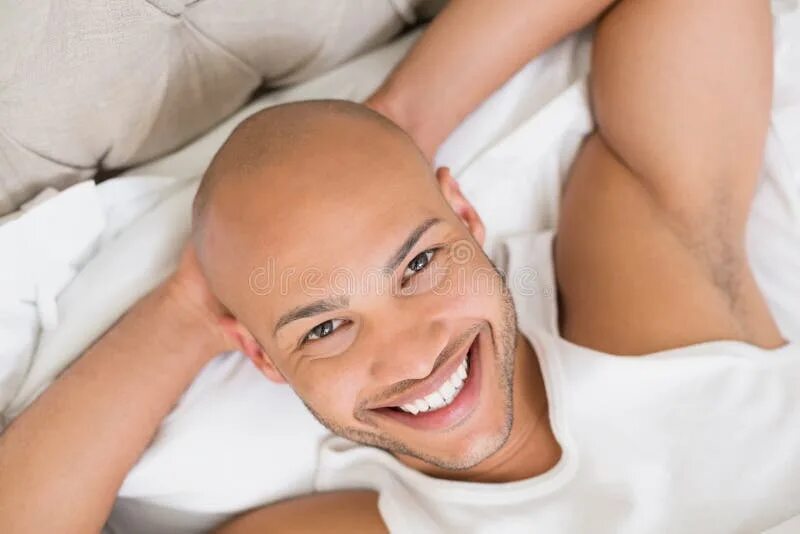Красивый мужчина лежит. Черноволосый мужчина. Утро человек просыпается. Лысый мужчина улыбка. Снится улыбаться парню.