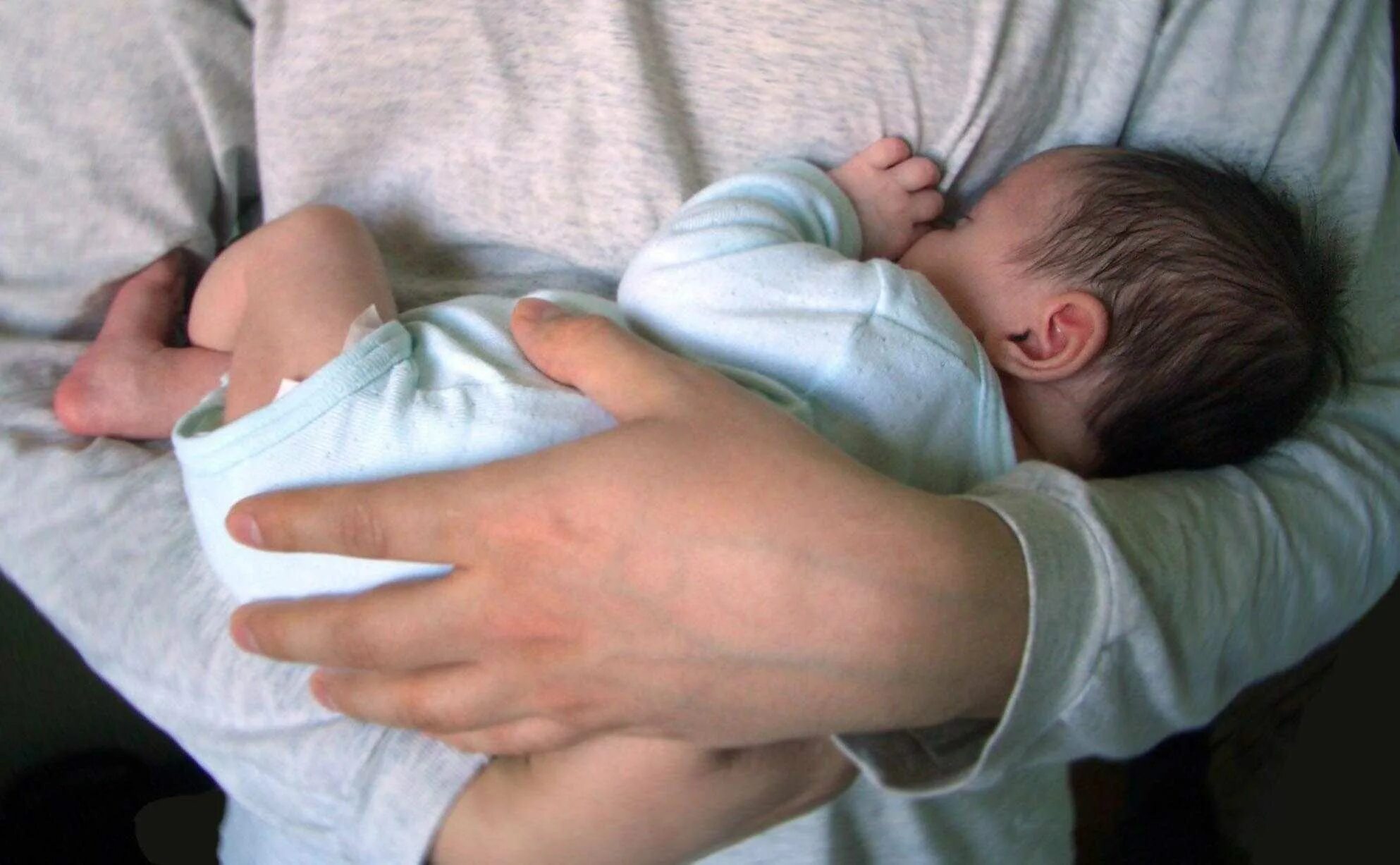 Матери снится маленький сын. Ребенок на руках. Новорожденный на руках. Рука новорожденного ребенка. Младенец на руках.