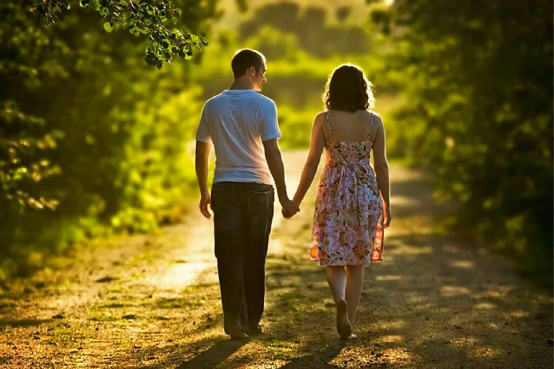 Парень и девушка идут за руку. Мужчина и женщина на природе. Идут за руку влюбленные. Мужчина и женщина гуляют.