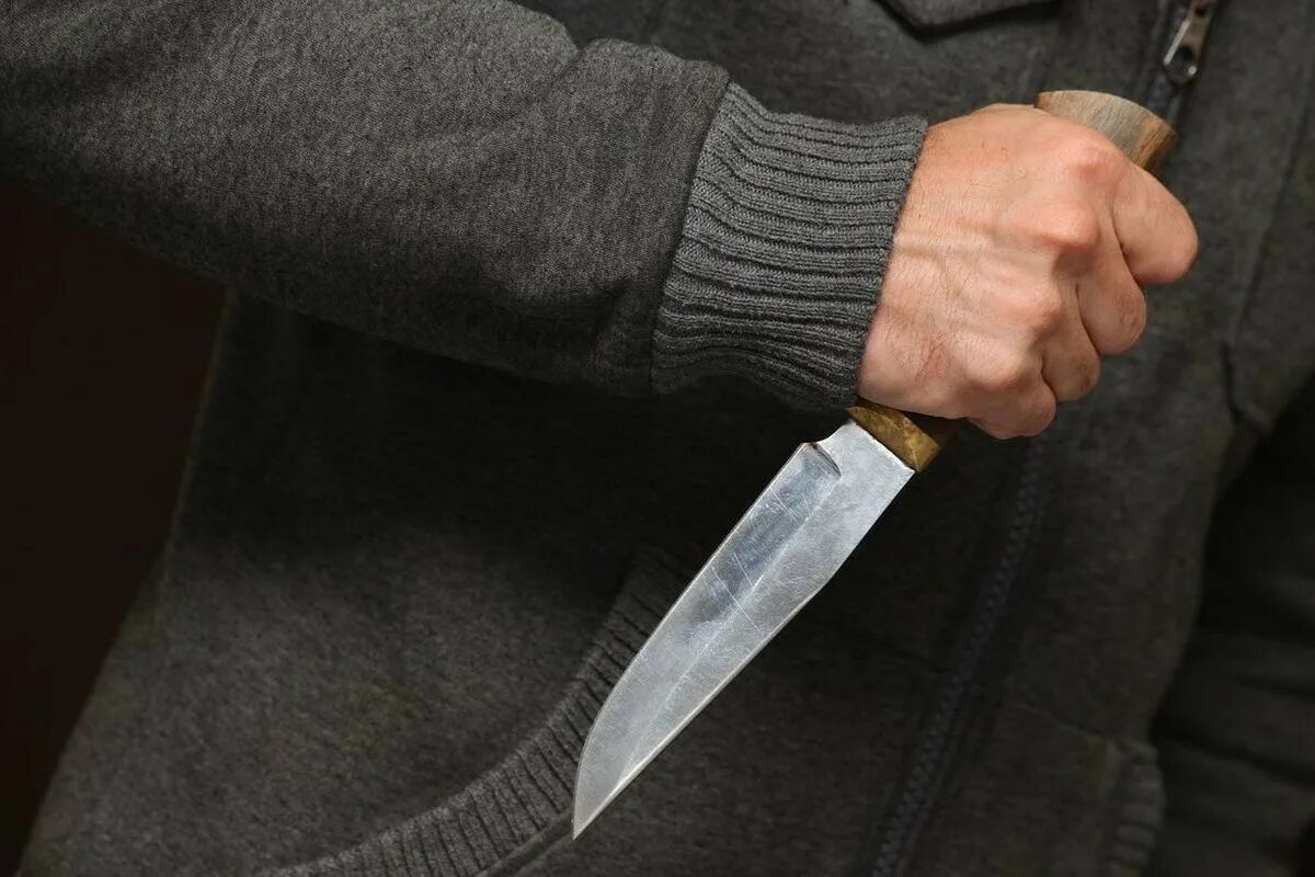 Мужчинская рука с ножом. Ножевое фото