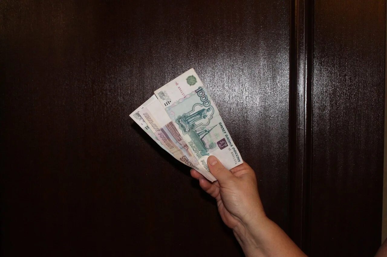 700 900 в рублях. Деньги в руках. Тысяча рублей в руке. Фотография денег в руках. Купюры на столе.